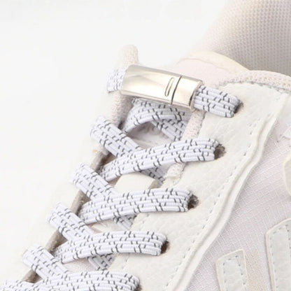 Close-up van magneetsluiting op witte reflecterende platte elastische veters voor veilige en eenvoudige schoenen