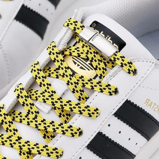 Zijaanzicht van gele pixel platte elastische veters met zwarte stippen met magneetsluiting voor een opvallende stijl zonder strikken